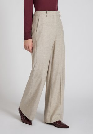 Beige wijduitlopende broeken met plooien en riemlussen, gemaakt van textuurstof. Gepaard met een bordeaux top en bordeaux puntige hakken.