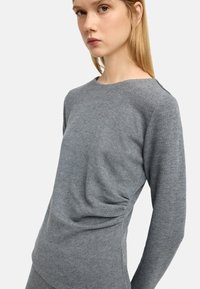 Szary, długi rękaw top z miękkiego materiału, z dekoltem typu łódka i marszczonym wykończeniem po bokach, o gładkiej fakturze i luźnym kroju.