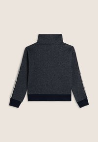 Pull navy scuro con colletto alto, caratterizzato da un tessuto testurizzato. Strisce bianche percorrono le maniche. Orlo e polsini a coste.