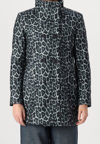 Cappotto doppiopetto con stampa leopardata, caratterizzato da un colletto alto, due grandi bottoni neri e un tessuto testurizzato con sfumature di grigio e nero.