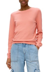 Sweat-shirt rose pâle texturé avec un col rond et des manches longues, associé à un pantalon cargo bleu clair taille haute avec des poches latérales.