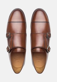 Braune Leder Schuhe mit polierter Oberfläche, ausgestattet mit doppelten Schnallen, runden Zehen und feinen Nähdetails.
