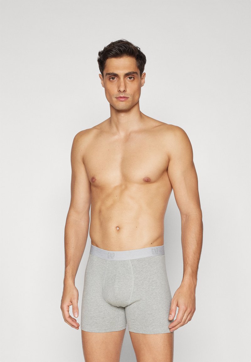 Grå bomull boxershorts med en myk elastisk midjebånd som har merket "GAP" i grå tekst. Designet for en snug passform.