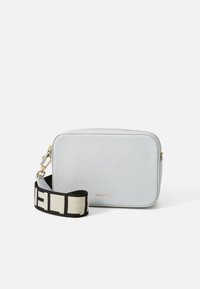 Borsa a tracolla rettangolare in pelle grigia chiaro con texture, dotata di tracolla larga con motivo bianco e nero e dettagli in metallo color oro.