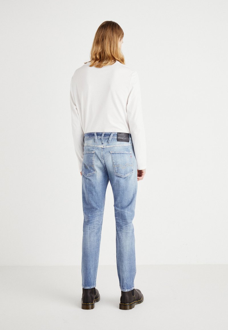 Hellblaue Jeans aus Denim mit geradem Schnitt, verblasster Textur und zwei Gesäßtaschen. Schwarzes Lederpatch am Bund.