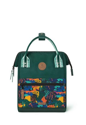 Dark green fabric bag with a colorful patterned front pocket, rectangular shape, short green handles, and zip closure. Logo badge on front.