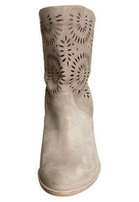 Beżowy zamszowy botek z wyciętym kwiatowym wzorem, gładką strukturą, zaokrąglonym noskiem i jasną podeszwą.