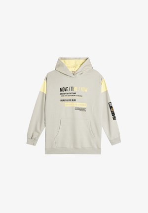 Lichtgrijze hoodie met een voorvak, gele accentstrepen en grafische tekst. Beschikt over een capuchon met trekkoord en geribbelde manchetten.