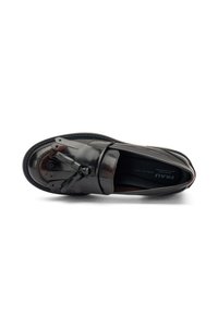 Zapato de cuero negro con un acabado brillante, presentando un diseño frontal único con acentos en capas y un detalle de lazo decorativo. Silueta clásica.