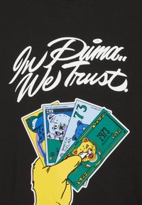 Czarny T-shirt z białym, kursywą napisem "W Pumę Wierzymy" nad kolorową ręką trzymającą ilustrowane karty z motywami zwierząt.