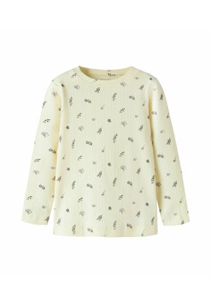 Roomkleurig geribd shirt met lange mouwen, kleine verspreide paarse en groene bloemenprint, ronde halslijn en reguliere pasvorm.