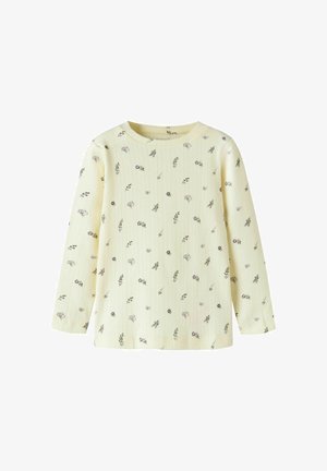 Chemise crème à manches longues en tissu côtelé avec un petit motif floral violet et vert dispersé, col rond et coupe régulière.