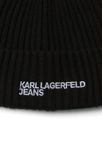 Juodas megztas kepurė su raukšlėta tekstūra, ant kurios yra balta siuvinėta užrašas "KARL LAGERFELD JEANS." Paprastas ir priglundantis dizainas.