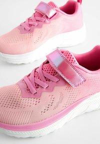 Baskets en mesh rose avec un dessus texturé, des lacets élastiques et une sangle velcro avec des accents métalliques. Semelle en caoutchouc blanche confortable.