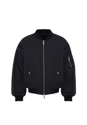 Veste bomber noire avec fermeture éclair à l’avant, deux poches inclinées à boutons-pression, col, poignets et taille côtelés, plus une poche zippée sur la manche gauche.