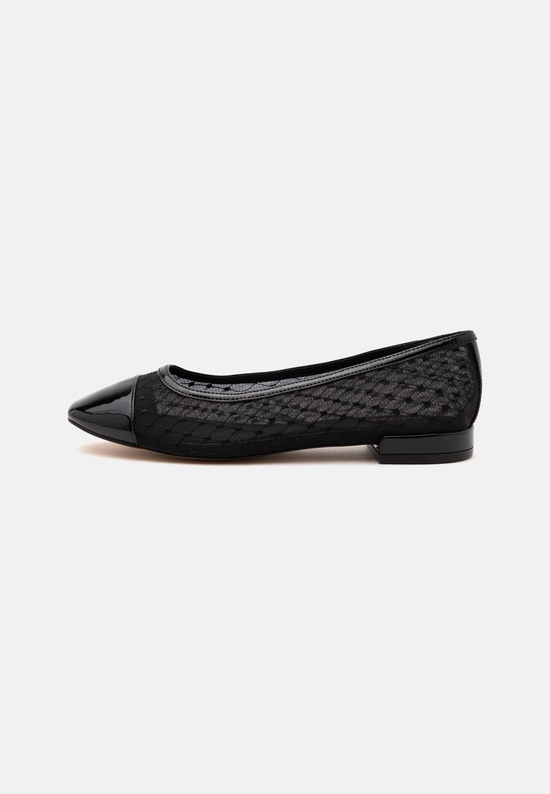 Chaussure plate noire pour femme avec bout pointu en cuir verni, côtés en mesh texturé et petit talon carré sur fond blanc.