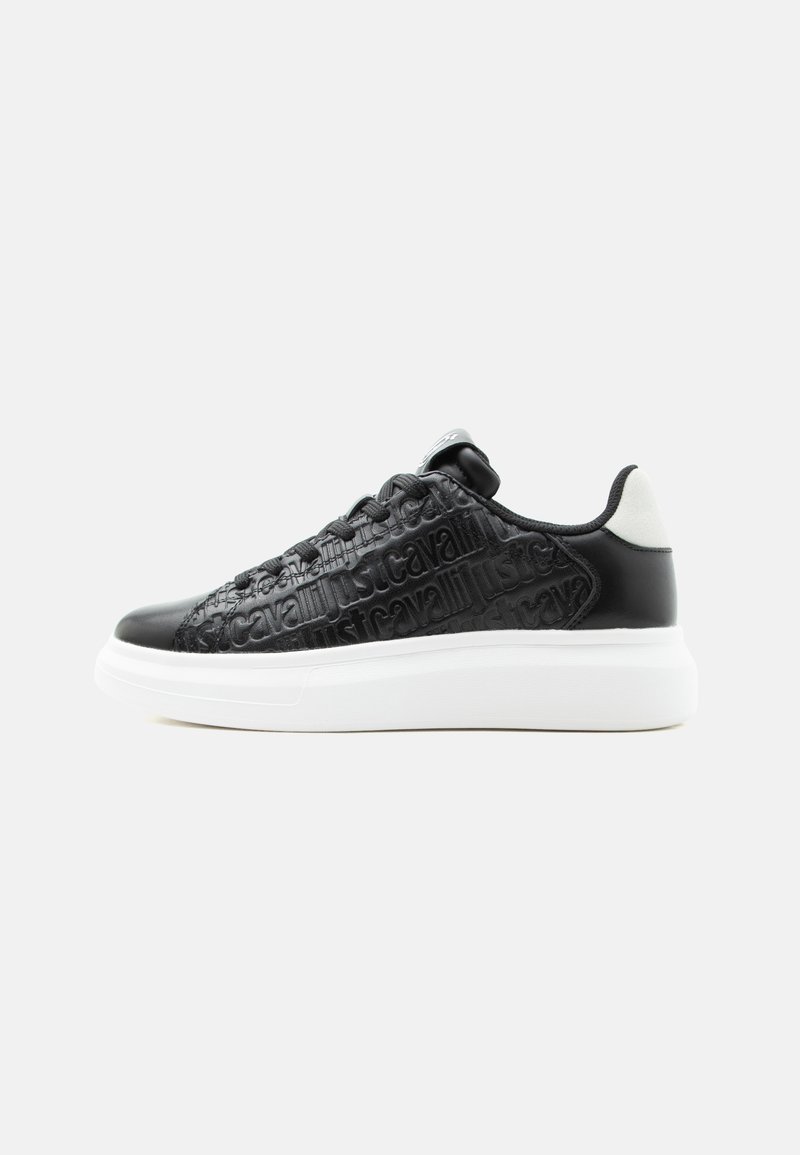 Czarny niski sneaker z wytłaczanym napisem "just cavalli", białą grubą podeszwą i białą pętelką z tyłu, pokazany z boku na białym tle.