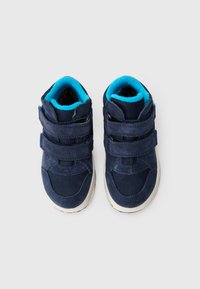 Para granatowych sneakersów dziecięcych z jasnoniebieskim wnętrzem i dwoma rzepami na białym tle.