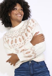Balta adīta džemperis ar ģeometrisku rakstu, kas dekorēts ar persiku un zelta akcentiem. Garas piedurknes ar ribotām aprocēm, pieskaņots tumši zil�ām džinsām.