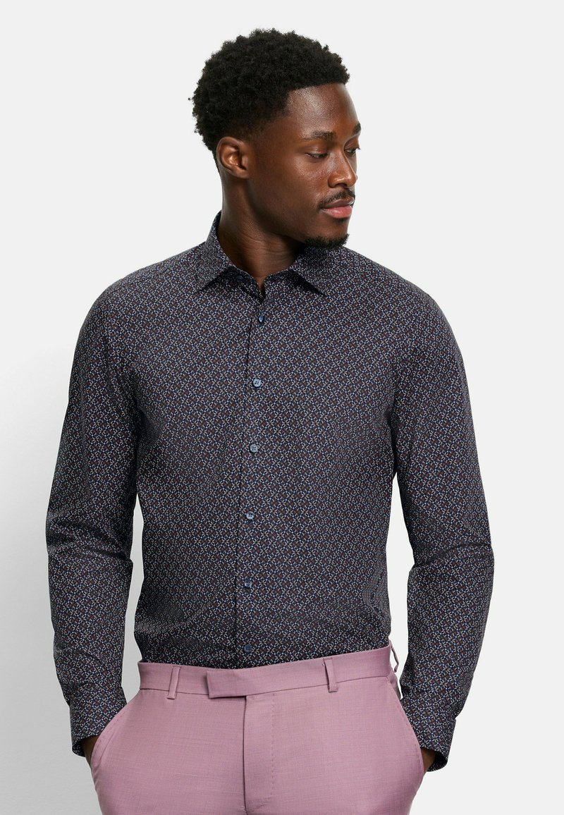 Camicia a maniche lunghe di un blu navy scuro con un motivo geometrico in blu chiaro e bordeaux. Presenta un colletto classico e chiusura con bottoni frontale.