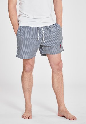 Pantaloni da bagno a righe con colori navy e bianchi, vita elastica con cordoncino e un piccolo logo sul lato sinistro.