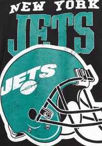 Černé tričko s tyrkysovým logem New York Jets, s designem fotbalové helmy a výrazným bílým písmem. Zvýrazněný opotřebený vzhled.