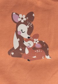 Illustrazione in stile cartoon di una madre cervo marrone e il suo cerbiatto su uno sfondo arancione, con accenti floreali e una superficie texturizzata.