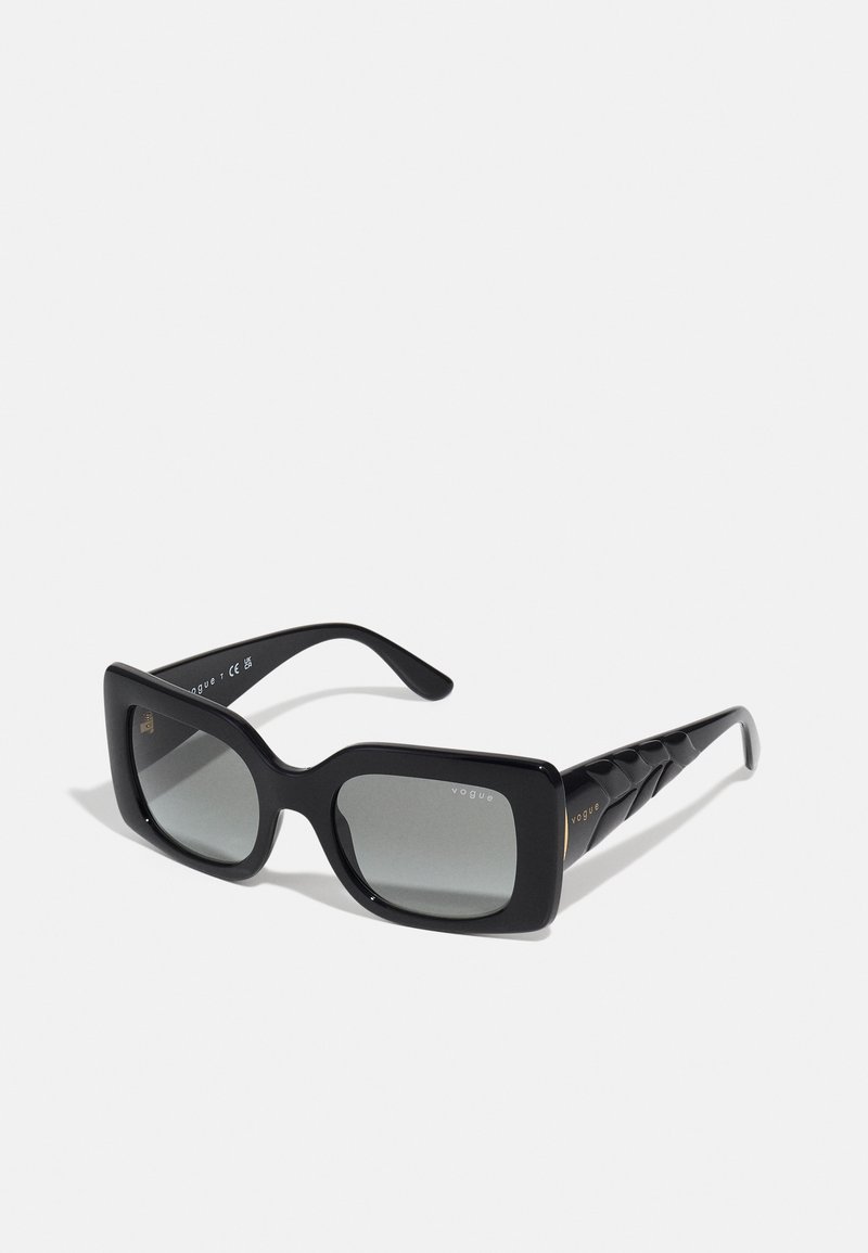 Óculos de sol retangulares pretos com lentes em degradê cinza. Armação de plástico brilhante, com hastes pretas texturizadas e um discreto detalhe de logótipo.