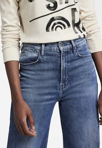 Ljusblå denimjeans med hög midja, utrustade med framfickor, knappgylf och en subtil tvättad textur.