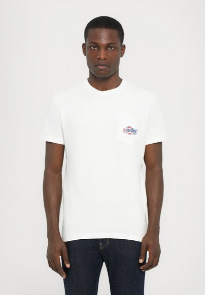 White cotton t-shirt with a round neckline and short sleeves. Features a front chest pocket with a colored logo design.