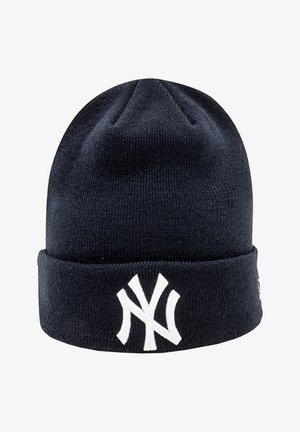 Berretto a maglia blu navy con risvolto, caratterizzato da un logo ricamato bianco dei New York Yankees sul davanti. Texture liscia, design semplice.
