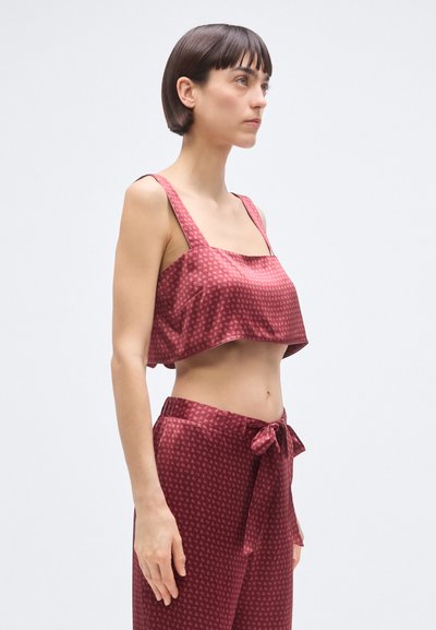 Lõigatud burgundiapunane satiinist top, millel on laiad õlapaelad ja peen kolmnurkmuster, sobitatud samast satiinist pükstega, millel on vööümbermõõduga lips.