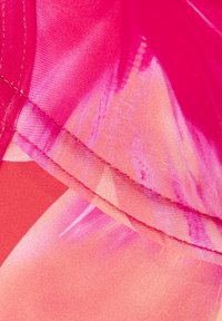 Roze stof met een mix van effen en gradient kleuren, een gladde textuur met een lichte glans, en nauwkeurige stiksels langs de randen.