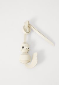 Portachiavi a forma di gatto in pelle color crema; presenta baffi e orecchie, con un design a spirale e una coda curva. Texture liscia su tutta la superficie.