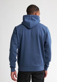Felpa con cappuccio blu scuro, dalla texture liscia, con polsini e orlo a costine, dotata di tasca a marsupio e vestibilità casual.
