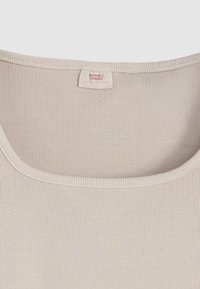 Μπεζ ριμπ φανελάκι με στρογγυλή λαιμόκοψη, με απαλή υφή και μικρή ετικέτα με το λογότυπο της Levi's στο κέντρο της πλάτης.