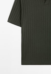 Dark green ribbed short-sleeve shirt with a V-neck design, featuring vertical stripes and a smooth texture. Hem sits straight with a clean finish.