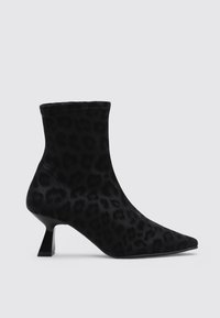 Botas negras hasta el tobillo con una textura suave, patrón de leopardo, punta afilada y un diseño de tacón geométrico corto.
