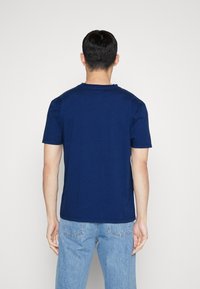 Marineblauw katoenen t-shirt met korte mouwen, ronde hals en een eenvoudig ontwerp. De stof heeft een zachte, gladde textuur.