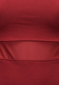 Κοντινή λήψη κόκκινου υφάσματος με οριζόντια επιφάνεια από δίχτυ και λεπτομέρειες ραφής.