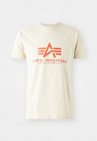 Beige cotton t-shirt featuring a prominent orange logo with an 'A' and three horizontal stripes. Short sleeves and crew neck design.
