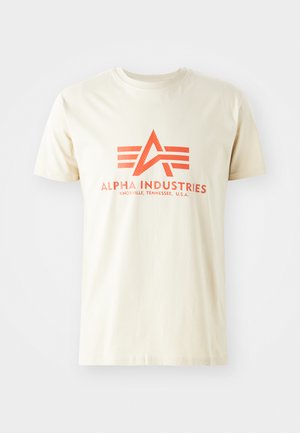 Beige t-paita, jossa on näkyvä oranssi logo, jossa on 'A' ja kolme horisontaalista raitaa. Lyhyet hihat ja pyöreä kaula-aukko.