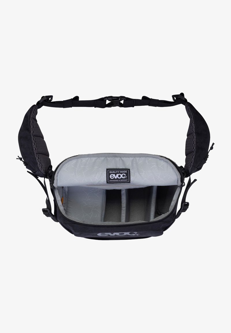 Sac messager noir avec bretelles rembourrées, intérieur gris et compartiments organisateurs. Dispose d'un écusson logo et d'une fermeture éclair.