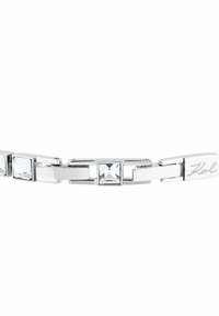 Silverfärgat metallarmband med fyrkantiga klara kristaller och ett graverat "Karl"-lås på vit bakgrund.