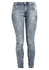 Vaqueros ajustados en denim azul deslavado, con detalles desgastados y acolchados en las rodillas. Diseño clásico de cinco bolsillos y con cremallera.