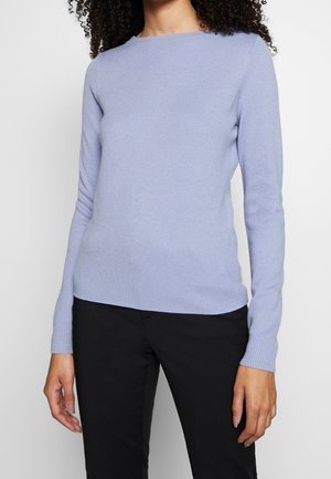 Pull en maille bleu clair avec des manches longues et un col rond. Présente une texture lisse et des poignets côtelés. Associé avec un pantalon noir.