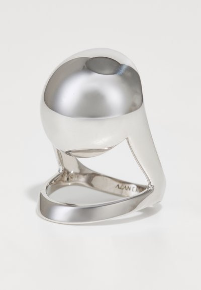 Inel din argint cu un vârf rotunjit, suprafață netedă și bandă deschisă cu decupaje sculpturale. Finisaj reflectant cu un design minimalist.