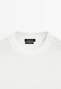 Witte gebreide trui met een ronde halslijn, gestructureerd patroon en een label met de teksten "Massimo Dutti" en "100% linnen." Lichtgewicht stof.