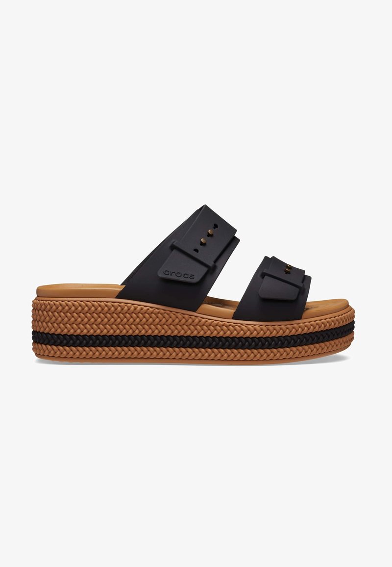 Sandales noires à enfiler avec des larges brides, en matériau texturé et avec des éléments décoratifs. Présente une plateforme tissée avec une bande marron et noire.