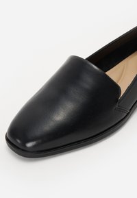 Svarte lær flate sko med en jevn tekstur, spiss tå-design og minimal søm. Tilbyr en slip-on stil for enkel bruk.